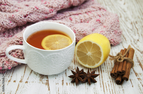 Cup of hot tea with lemon and scarf