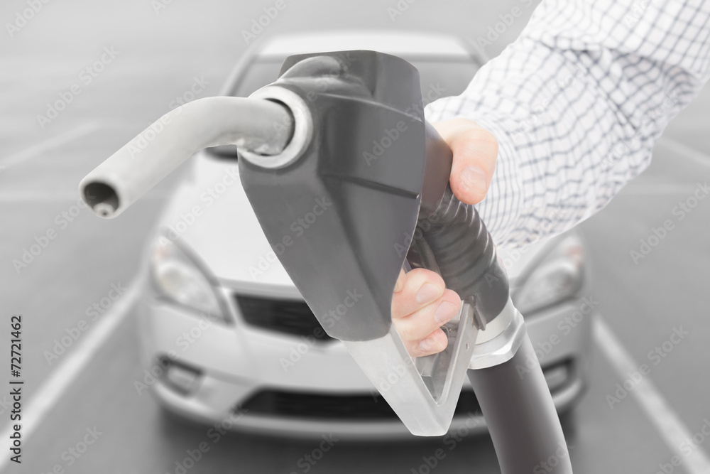 Φωτογραφία Black color fuel pump gun in hand with car on background