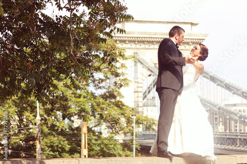Photography Bride and groom having fun on a bridge in Budapest, Hungary