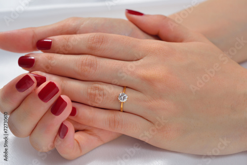 Wedding ring on hand of bride on white cloth