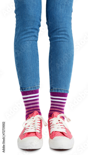 Female legs in colorful socks and sneakers isolated on white
