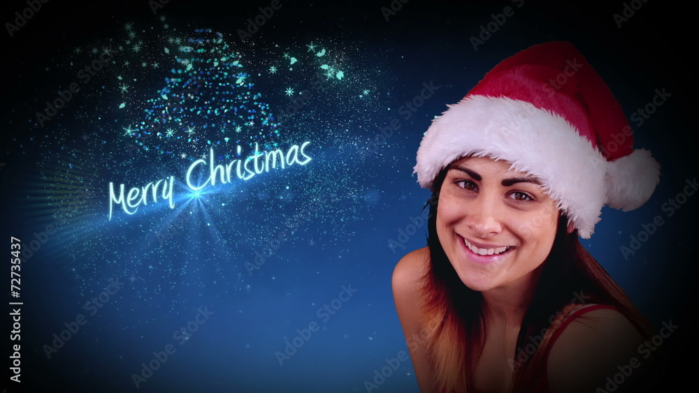 Festive brunette blowing a magical christmas greeting