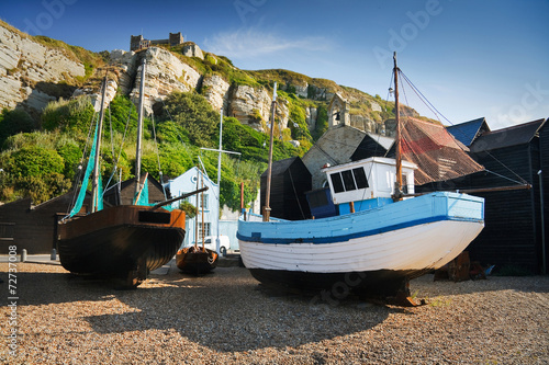 Boats among historic net huts in Hastings harbour, UK.