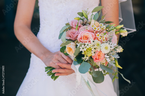 Beautiful wedding bouquet in hands of the bride