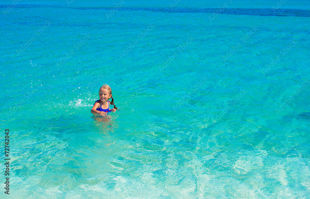 Adorable little girl have fun at tropical beach