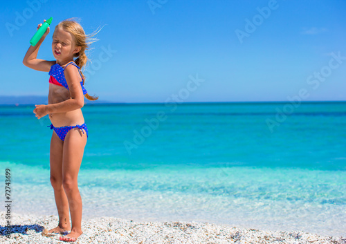 Adorable little girl have fun at tropical beach in shallow water