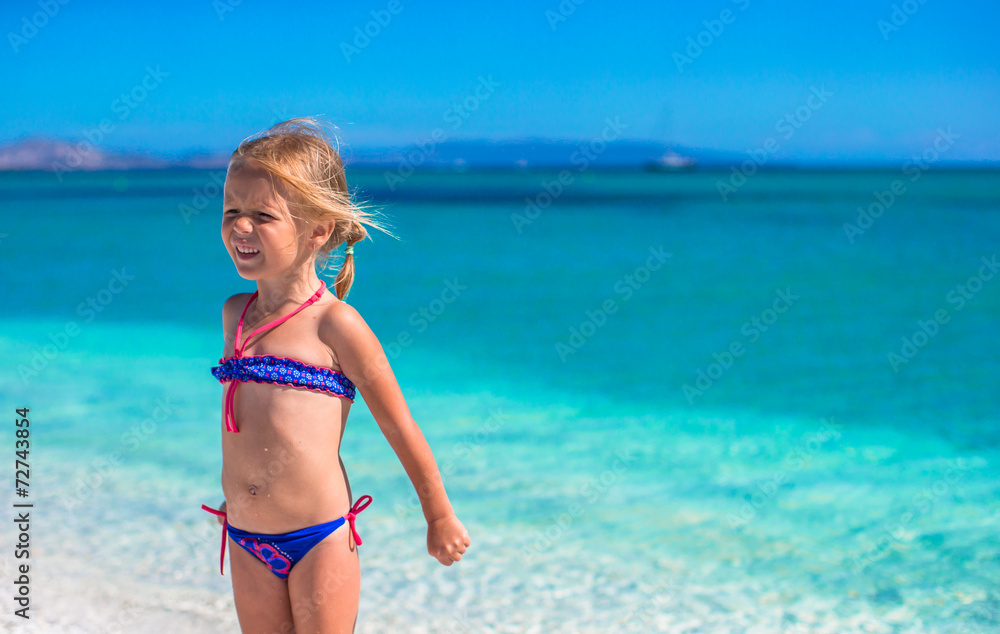 Adorable little girl at tropical beach during summer vacation