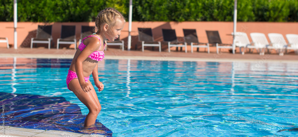 Adorable happy little girl enjoy swimming in the pool