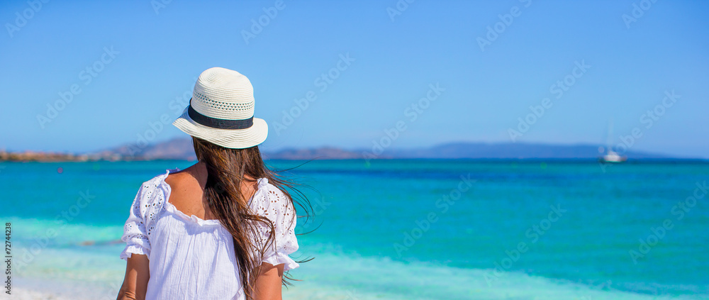 Young beautiful woman sitting on the beach with word Love