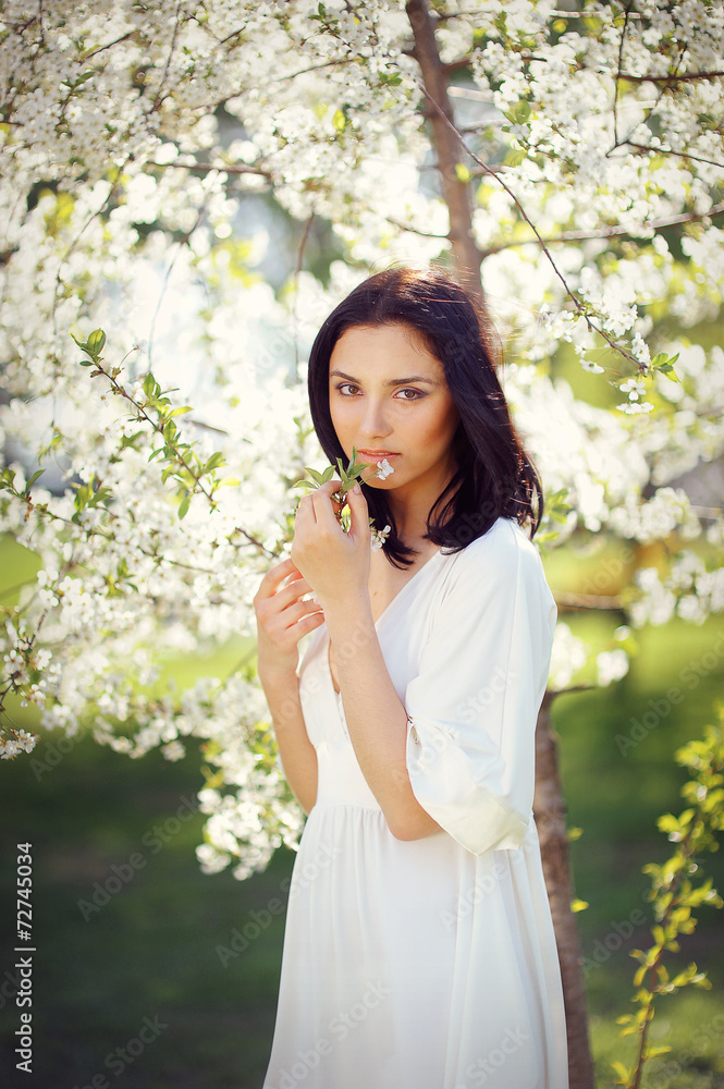 beautiful brunette in the spring in a flowery park beautiful brunette in the spring in a flowery park