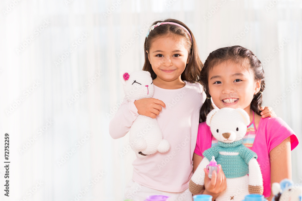 Portrait of cute little girls posing with their toys Portrait of cute little girls posing with their toys