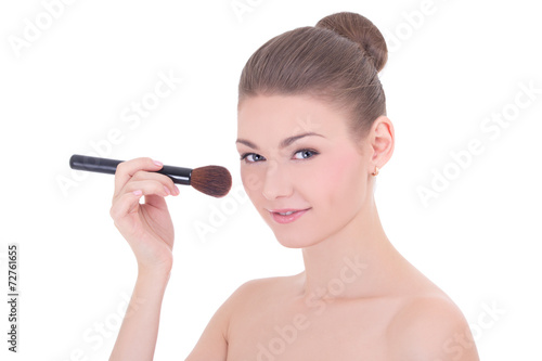 portrait of young beautiful woman applying rouge or powder with