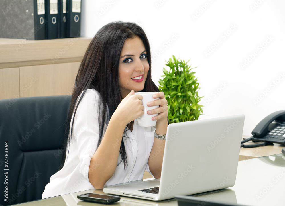 Young pretty business woman having coffee in office Young pretty business woman having coffee in office