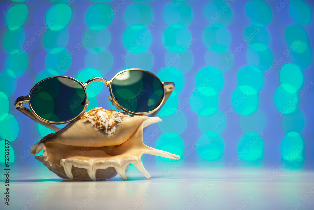 Retro sunglasses with shell and blurry shiny colored background Retro sunglasses with shell and blurry shiny colored background