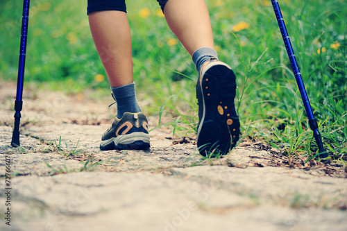 young fitness woman legs walking on grass trail