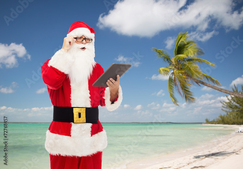man in costume of santa claus with tablet pc
