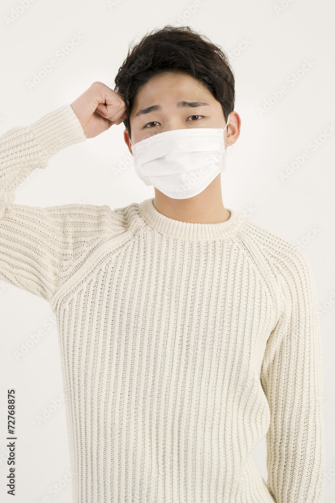 Asian man wearing a face mask with headache Asian man wearing a face mask with headache