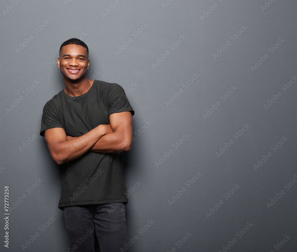 Happy young man standing with arms crossed Happy young man standing with arms crossed
