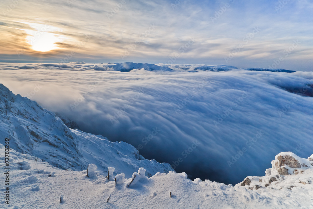 sunset over the mountains and clouds in winter