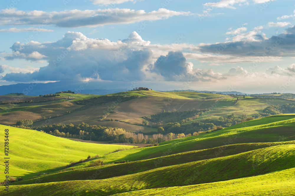 Tuscan landscape with clouds and green fields, Italy