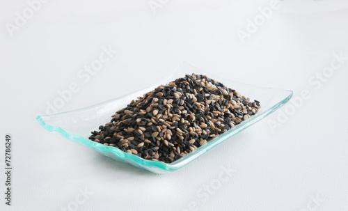 Mix of black and white sesame seeds on a glass plate