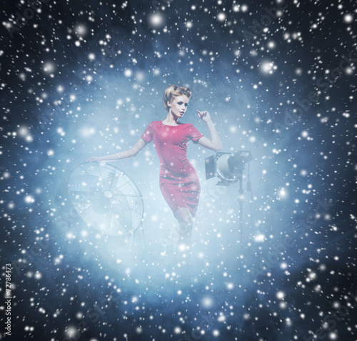 Young woman in a fashion dress on a snowy background