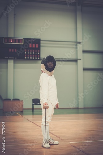 Little girl fencer with epee and mask