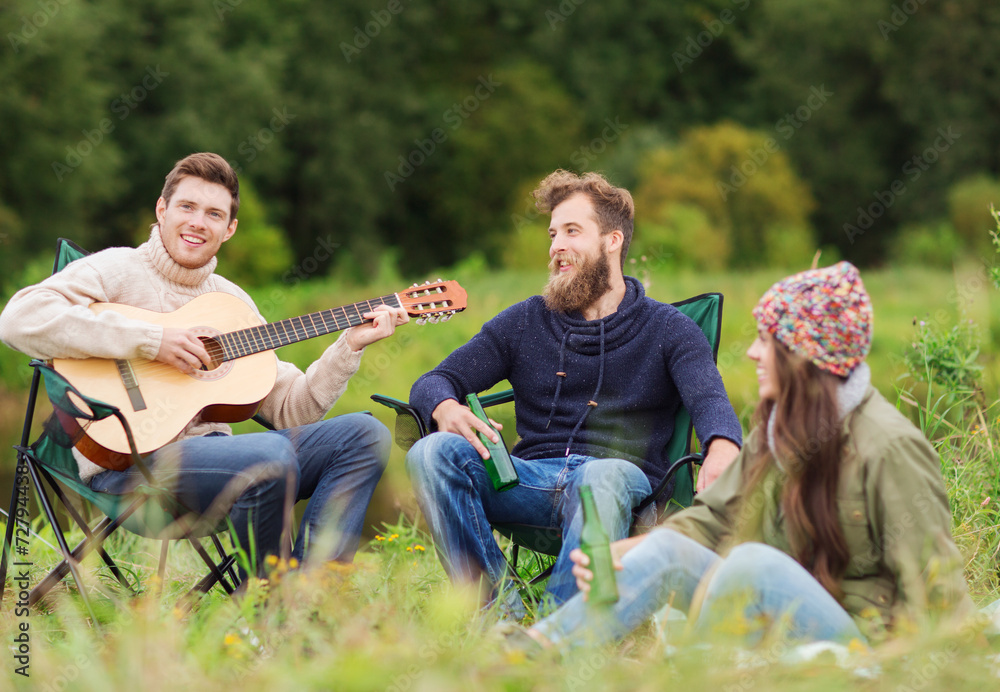 group of tourists playing guitar in camping group of tourists playing guitar in camping