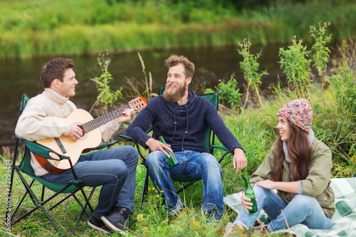 group of tourists playing guitar in camping