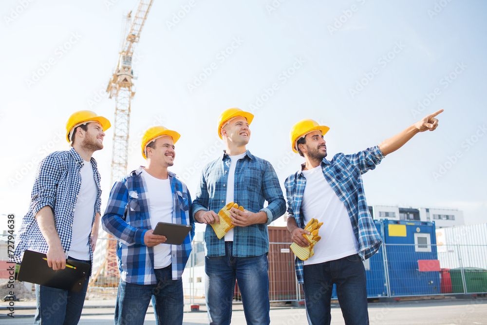 group of smiling builders with tablet pc outdoors group of smiling builders with tablet pc outdoors