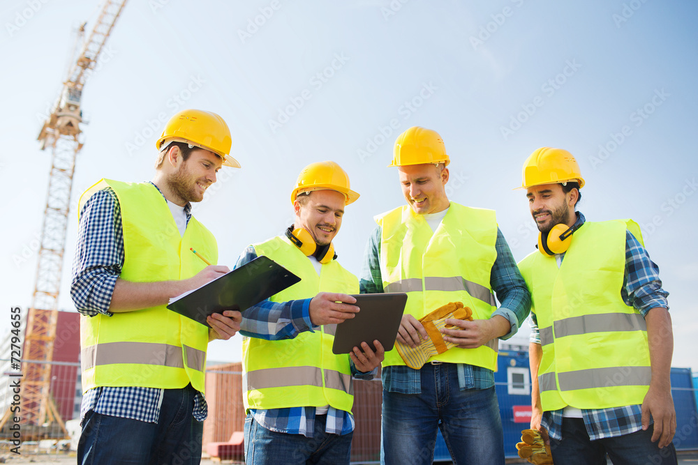 group of smiling builders with tablet pc outdoors group of smiling builders with tablet pc outdoors