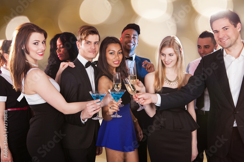 Happy Friends Toasting Drinks At Nightclub