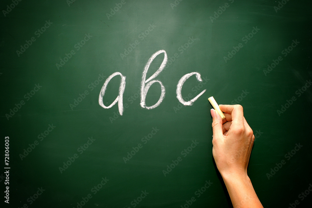 abc letters and chalk with woman hand on blackboard