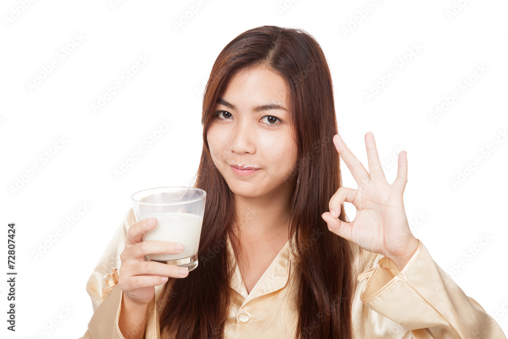 Happy Asian woman in pajamas drink milk show OK sign Happy Asian woman in pajamas drink milk show OK sign