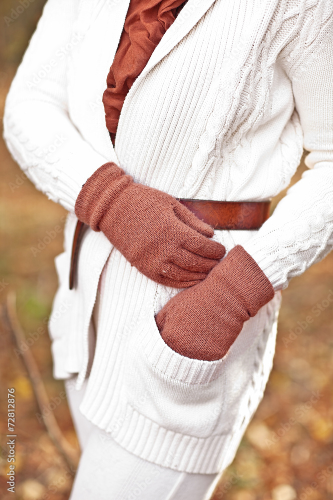 woman in a white sweater, gloves and scarf  in the fall autumn