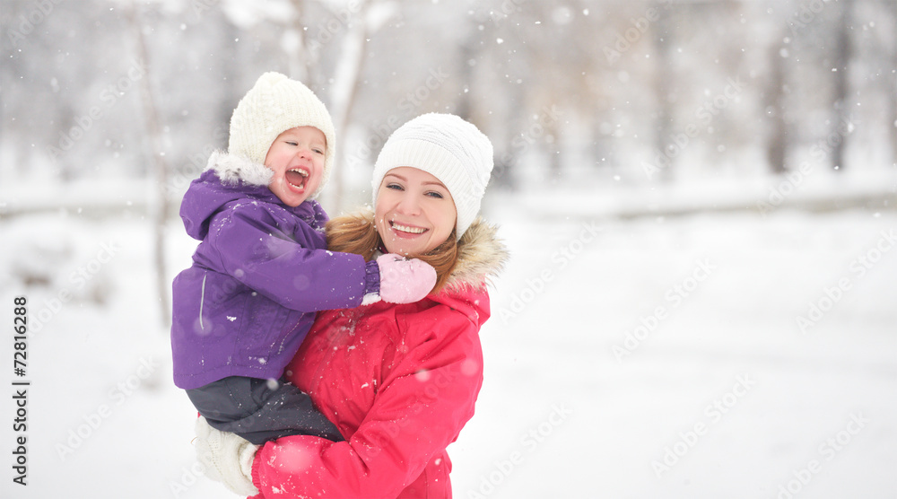 happy family mother and baby girl daughter playing in winter