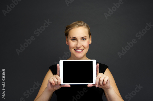 Business woman holding a tablet computer - isolated over a dark