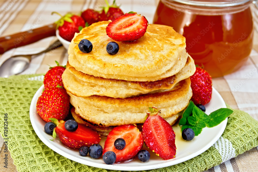 Flapjacks with strawberries and blueberries on napkin Flapjacks with strawberries and blueberries on napkin