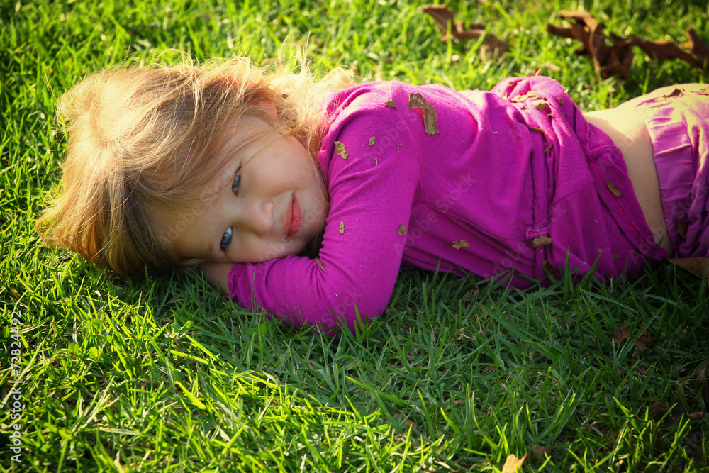 Little lovely girl playing on the grass in the park. filtered im Little lovely girl playing on the grass in the park. filtered im