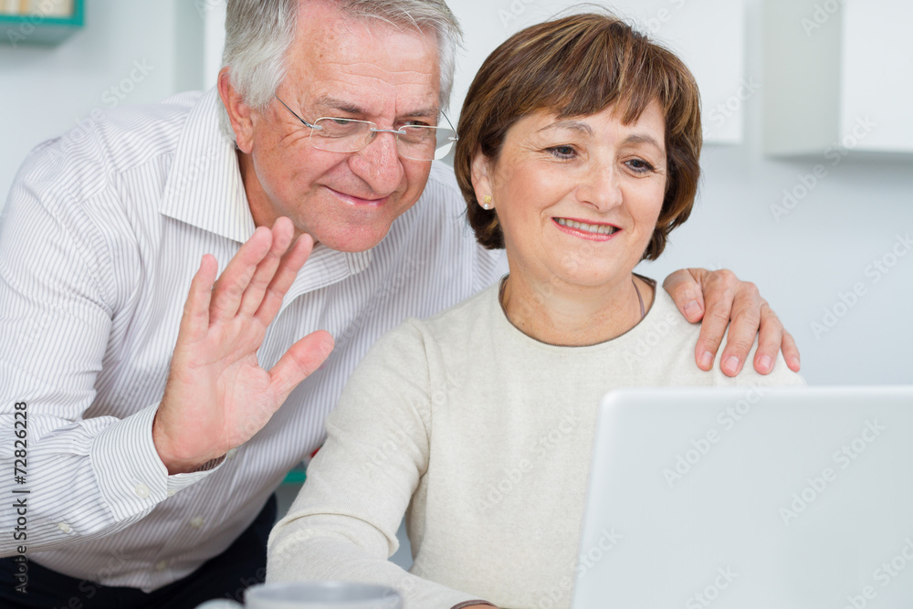 Seniors couple using a computer talking with video chat Seniors couple using a computer talking with video chat
