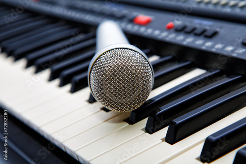 The microphone lies on the synthesizer keyboard