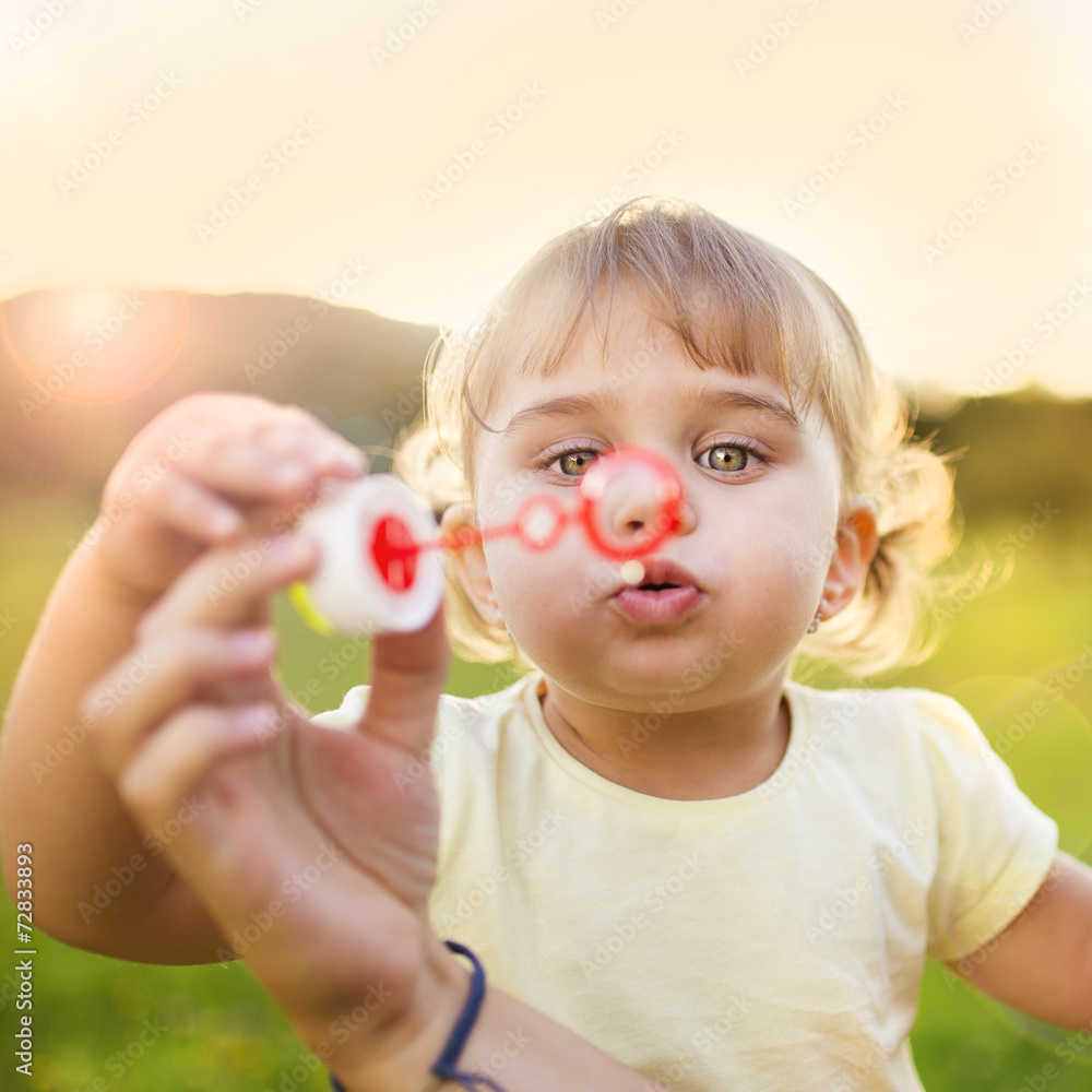 Little girl blowing bubbles in nature Little girl blowing bubbles in nature
