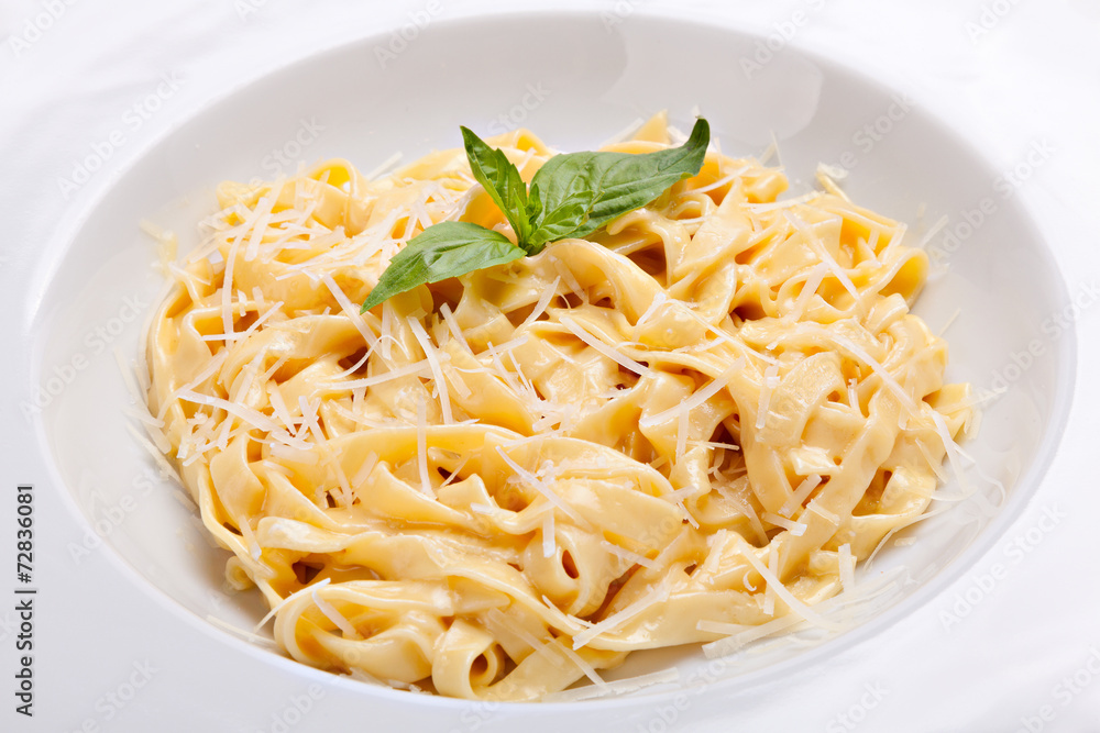 Close-up italian pasta plate with grated parmesan cheese and bas