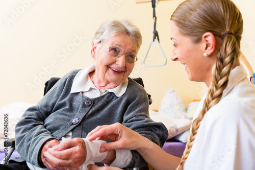 Canvas Print Pflegerin kümmert sich um Seniorin in Altenheim