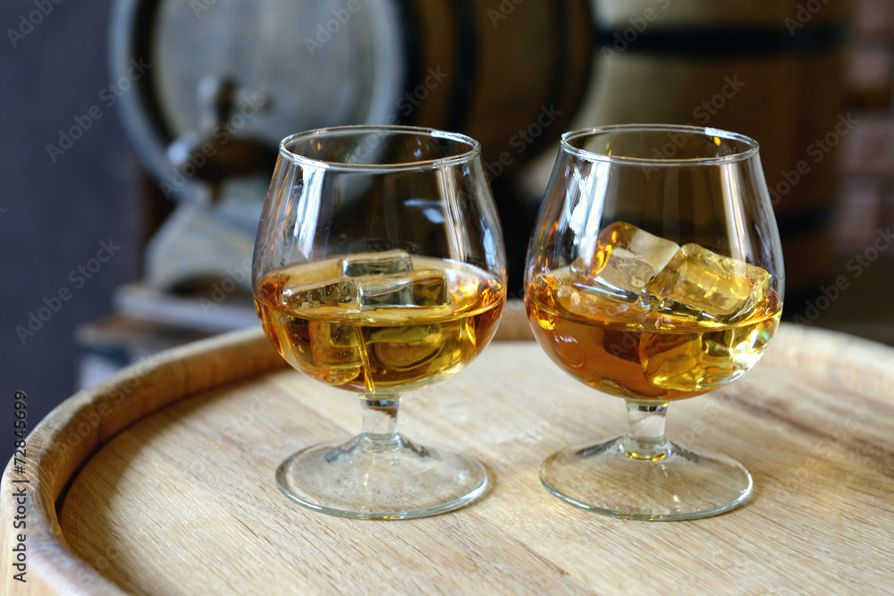 Glasses of brandy in cellar with old barrels Glasses of brandy in cellar with old barrels