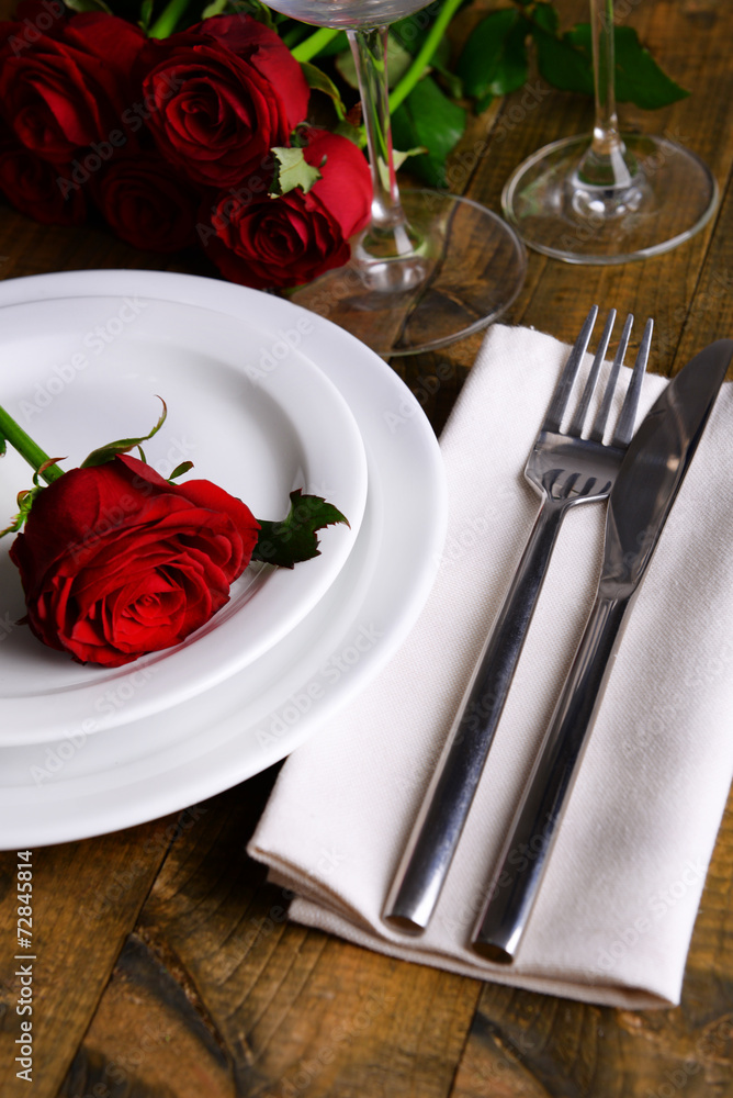 Table setting with red rose on plate Table setting with red rose on plate