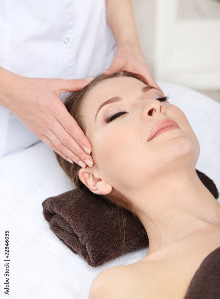 Beautiful young woman having massage in spa salon