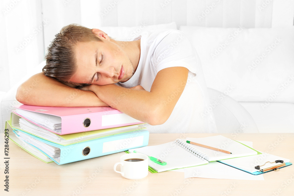 Tired man with many folders sleeps on table Tired man with many folders sleeps on table
