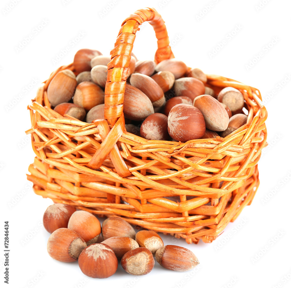 Hazelnuts in wicker basket isolated on white Hazelnuts in wicker basket isolated on white