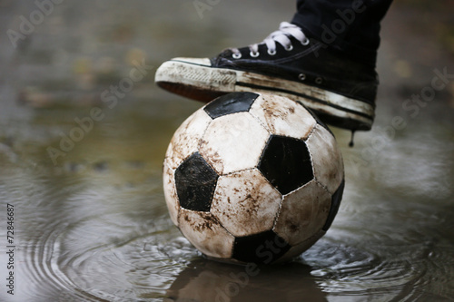 Soccer ball on ground in rainy day, outdoors © Africa Studio